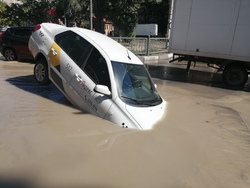 Такси наполовину ушло в яму с водой
