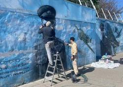 Художник начал восстановление граффити с героями войны на набережной