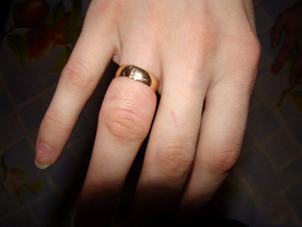 Лопнуло золотое кольцо. Обручальное кольцо на пальце. Золотые обручальные кольца на руках. Толстое обручальное кольцо женское.